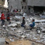 People sit amid rubble during Eid al-Fitr, in Gaza City